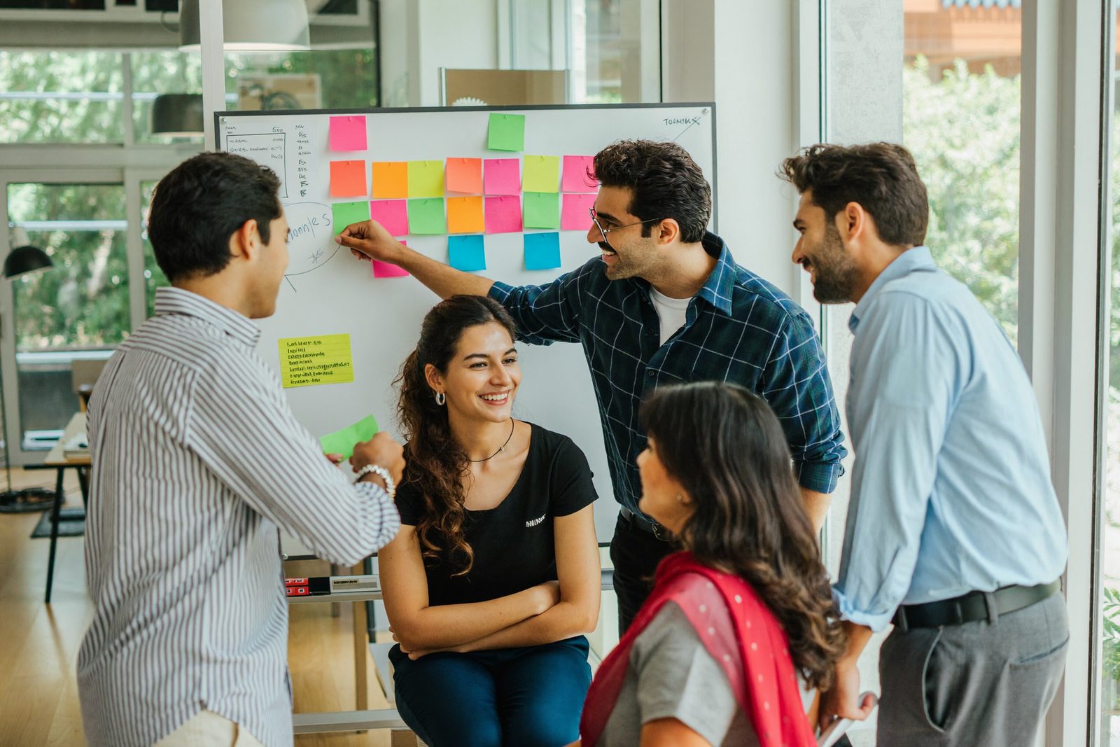 The team huddled around a whiteboard full of sticky notes